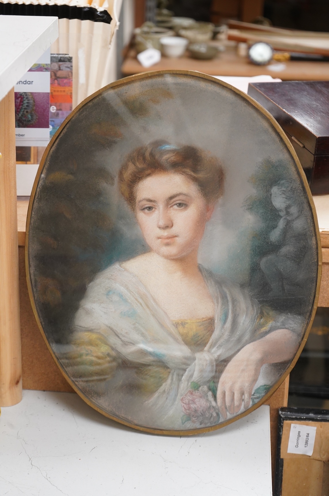 Late 18th century School, Portrait of a young lady holding a rose, oval pastel, 40 x 33cm